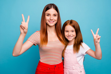 Pretty foxy small lady and her mom showing v-sign symbol wear casual clothes isolated blue...