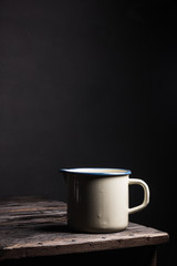 Old enameled saucepan on rustic wooden table