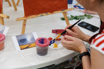 Fototapeta na wymiar Young artists learn to paint a landscape in watercolor