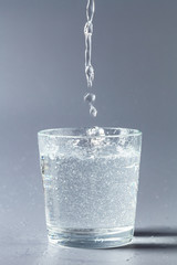 Close up pouring purified fresh drink water from the bottle on table