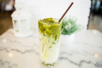 Iced Green milk tea macchiato in the glass with straw