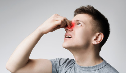 Young man touching his bleeding nose, panorama