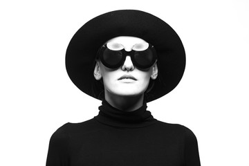 Stylish black and white portrait of elegant slim girl in glasses and a hat.