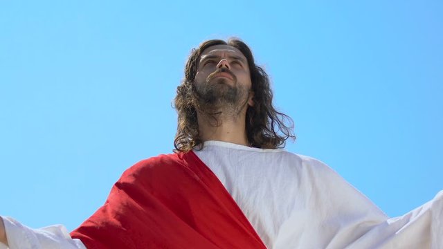 Blessed Jesus Christ raising hands to sky, praying father, asking God for mercy