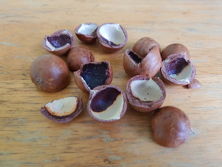Empty mecademia nuts' shells on a wooden table 