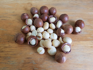 Pile of macadamia nuts with nut shells on a wooden table