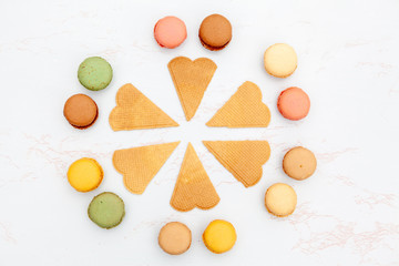 Fun flat lay composition of the colorful and sweet tasting small French cake macaron or macaroon combined with cookies