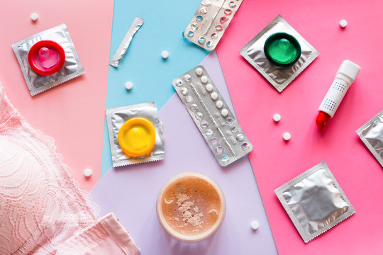 cosmetics, bra, condoms and birth control pills on a colored background. concept contraception
