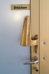 Door with handle and a sign with the german word for press