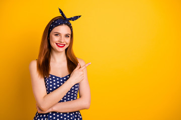 Photo of beautiful foxy lady indicate empty space low prices wear dotted dress headband isolated yellow background