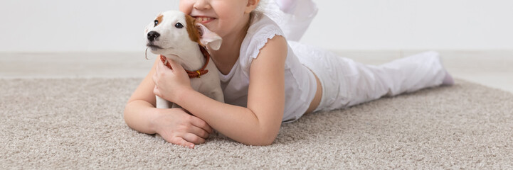 Pet, children and animal concept - Adorable child girl and funny puppy having fun close-up