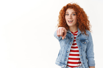 Amazed surprised attractive redhead woman see famout person awesome product pointing index finger...