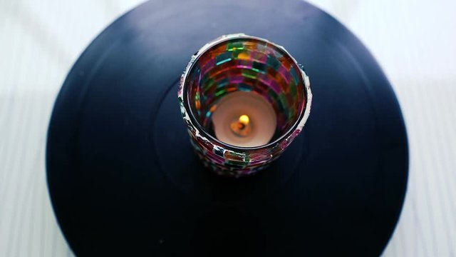 Candle rotating on dark background. Candle in colorful jar