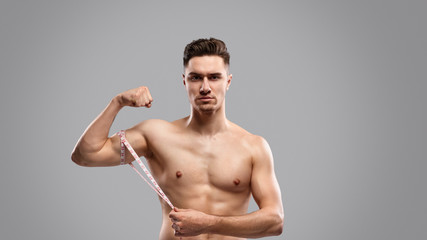 Fototapeta premium Serious guy measuring arm muscles
