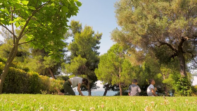 Mother with two boys doing yoga and relaxation exercises outdoors. Happy family concept. Happy childhood background. Grandmother with children and grandchildren doing morning exercises Happy childhood