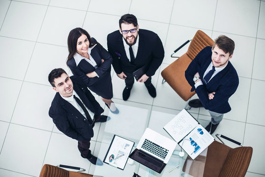 professional business team looking up standing near desktop
