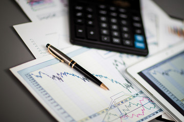 tablet,calculator,pen and financial charts in the workplace businessman