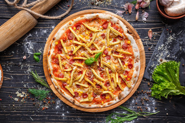 Hot pizza with hunting sausages and French fries