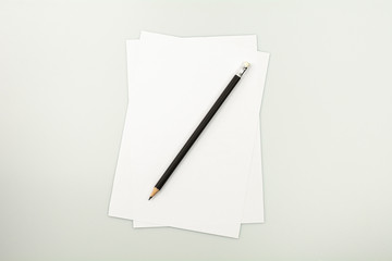blank note paper and a pencil on white desk background.