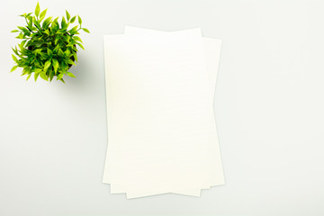 Piles of paper on the white desk background with a copy space - top view.