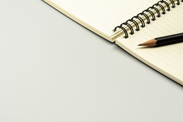 diary book and a pencil on grey desk background with copy space. - top view.