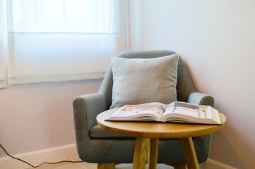 Grey sofa in living room with wood table and book