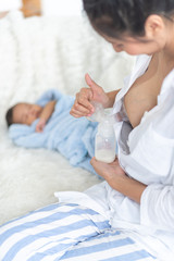 Obraz na płótnie Canvas Mom is pumping milk to the baby bottle.