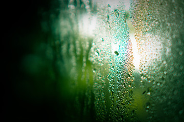 Glass with water droplets and cold vapor, green vintage tone