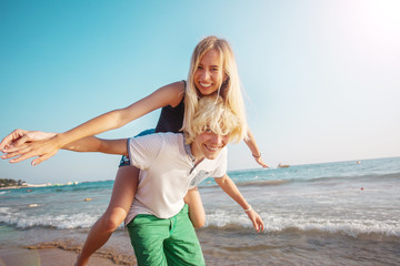 Fototapeta premium Happy young couple having fun at beach on sunny day