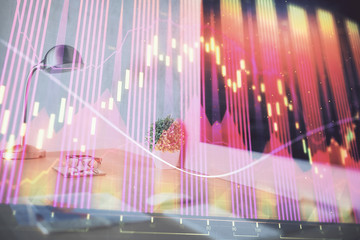 Stock market graph on background with desk and personal computer. Multi exposure. Concept of financial analysis.