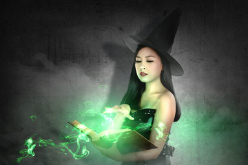 Asian witch woman in hat learns the spell from the magic book