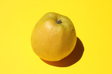 Fototapeta premium Ripe yellow apple on yellow background