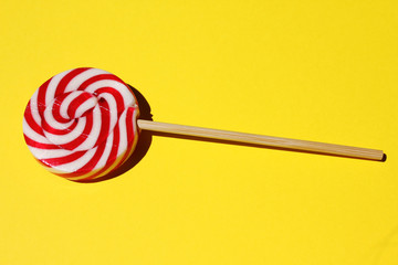 Red spiral lolli pop on a yellow background