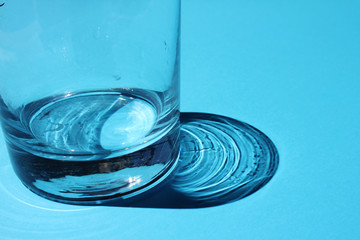 Empty glass on a blue bright background with sunlight
