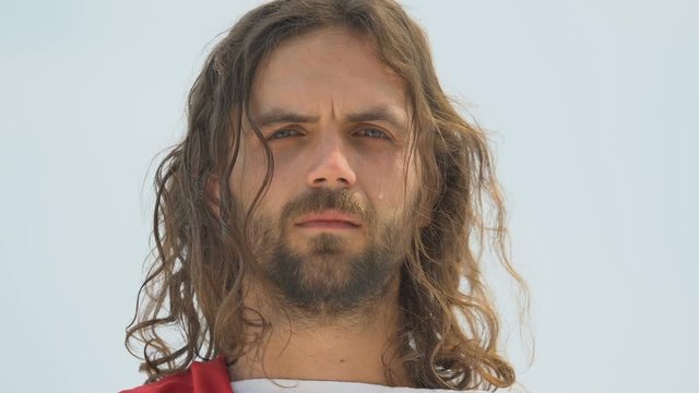 Tear falling down Jesus cheek, merciful God forgiving humanity sins, closeup