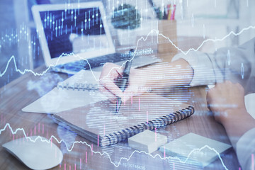 Fototapeta premium Financial charts displayed on woman's hand taking notes background. Concept of research. Double exposure
