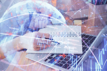 Financial charts displayed on woman's hand taking notes background. Concept of research. Double exposure