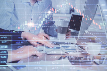 Multi exposure of chart with man typing on computer in office on background. Concept of hard work.