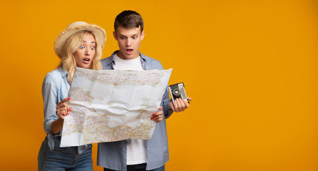 Couple of travellers looking on map with shock
