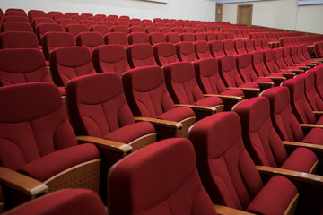 Close-up shot of red chair seats in empty conference room