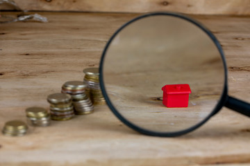 Coins Stack, House and Magnifying Glass