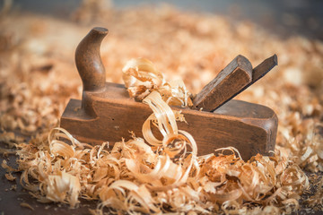Old wooden hand plane for woodworking with wood shavings.