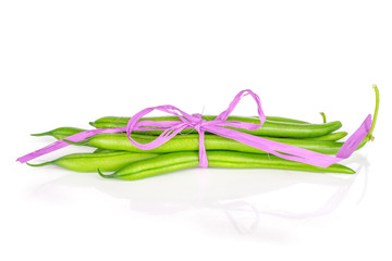 Lot of whole fresh green bean with pink bast bow isolated on white background