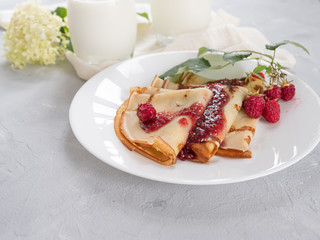 Homemade pancakes with raspberry jam, natural milk. Copy space.