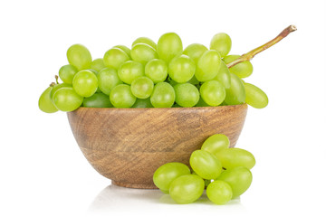 Lot of whole fresh green grape small bunch is aside in big wooden bowl isolated on white background