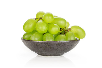 Lot of whole fresh green grape in dark ceramic bowl isolated on white background