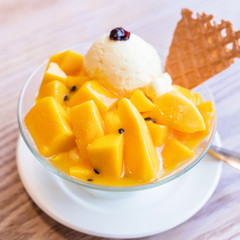 Fresh mango shaved ice with a scoop of ice cream and juice sauce in summer restaurant, lifestyle, popular food in Taiwan, close up.