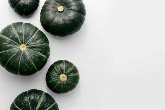 Green pumpkins on a white background, creative flat lay thanksgiving concept, top view with copy space