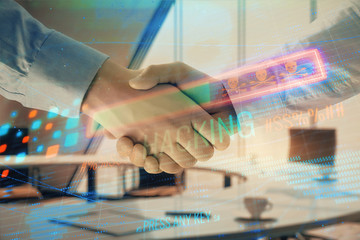 Double exposure of hacking theme hologram on office background with two men handshake. Concept of data security