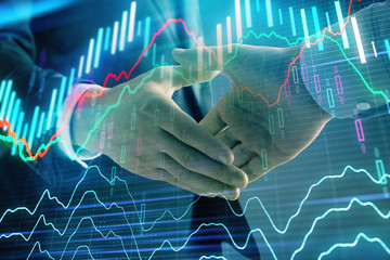 Multi exposure of forex graph on abstract background with two businessmen handshake. Concept of success on stock market